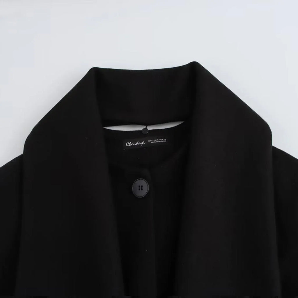 Women's long grey wool blend overcoat with a large artificial fur collar and pockets.