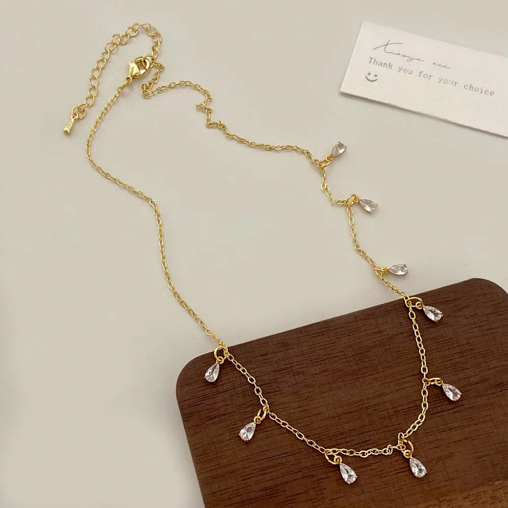 Women's zircon jewellery set showing geometric necklace, matching earrings, and anklet with meteor shower design.
