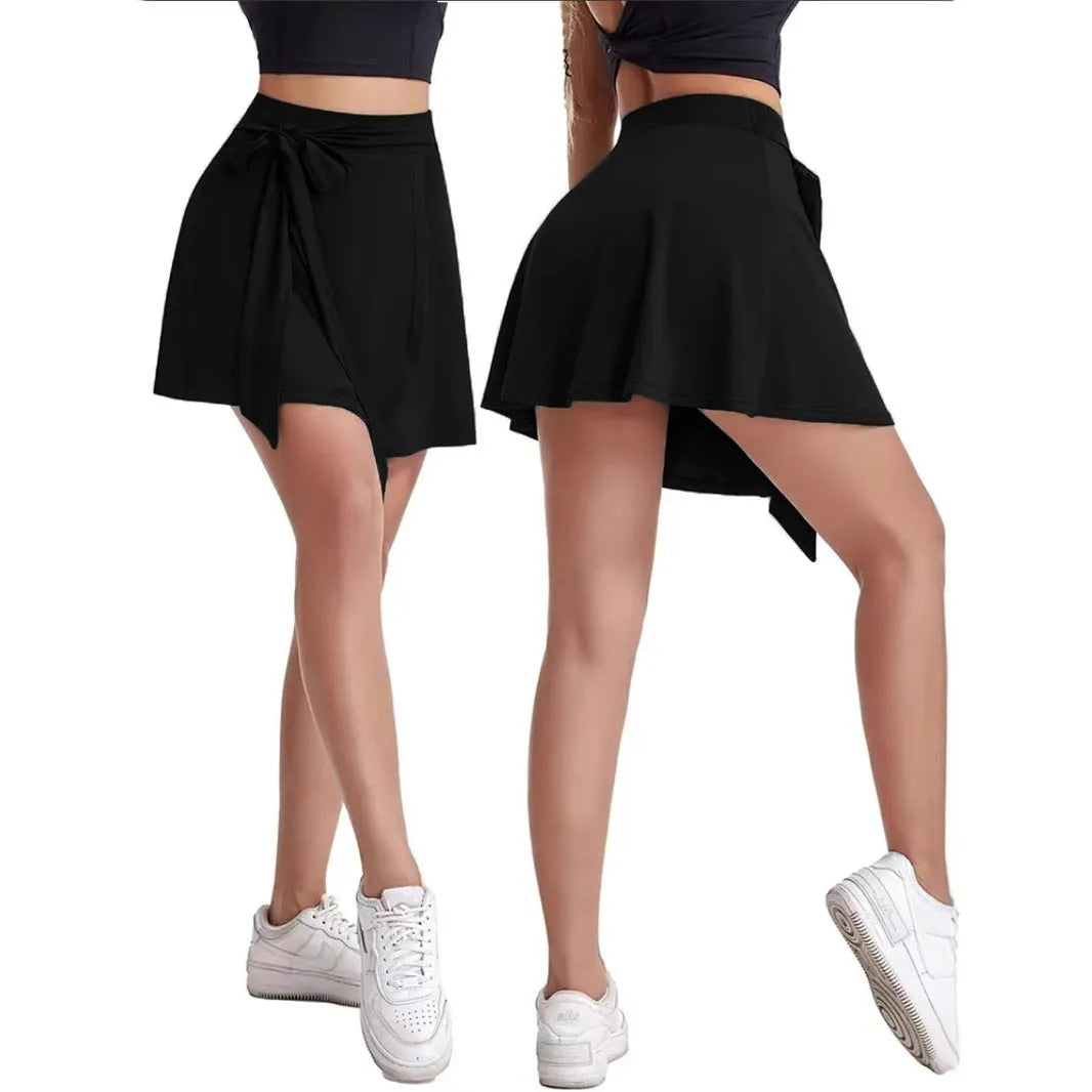 Black unisex thigh-length sports skirt with strap details and built-in shorts on a mannequin.