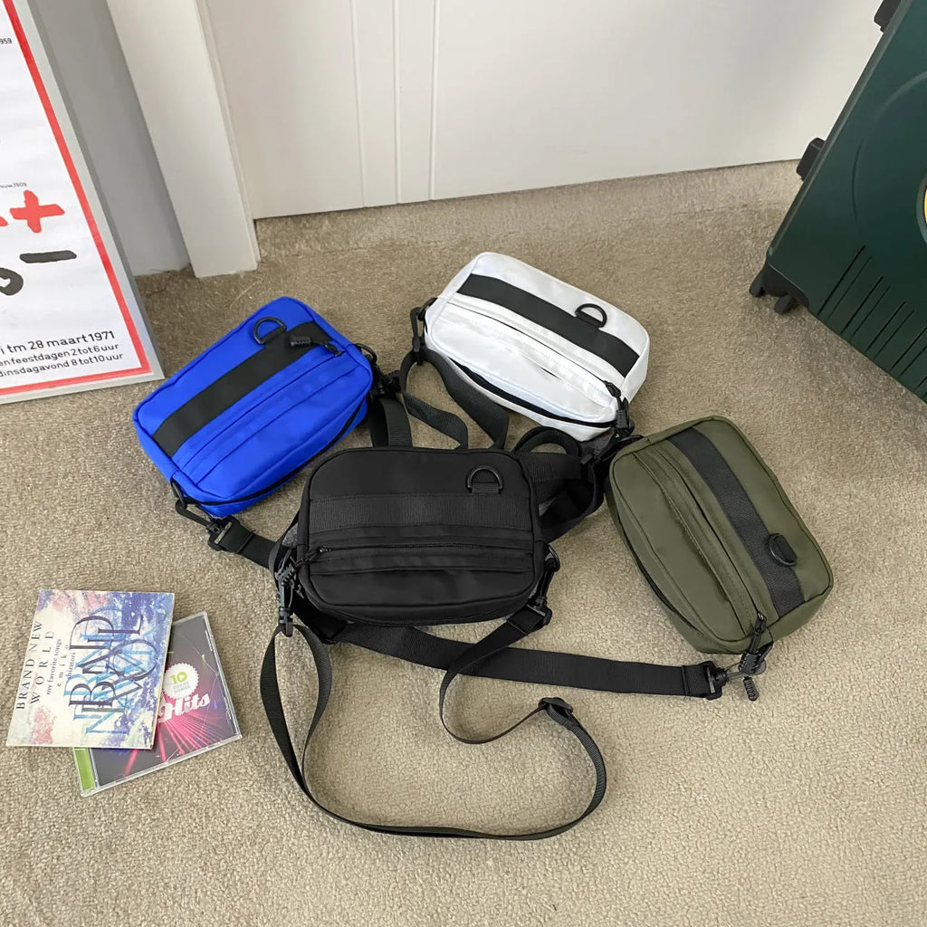 Men's solid colour nylon messenger bag with crossbody strap, shown in street style.