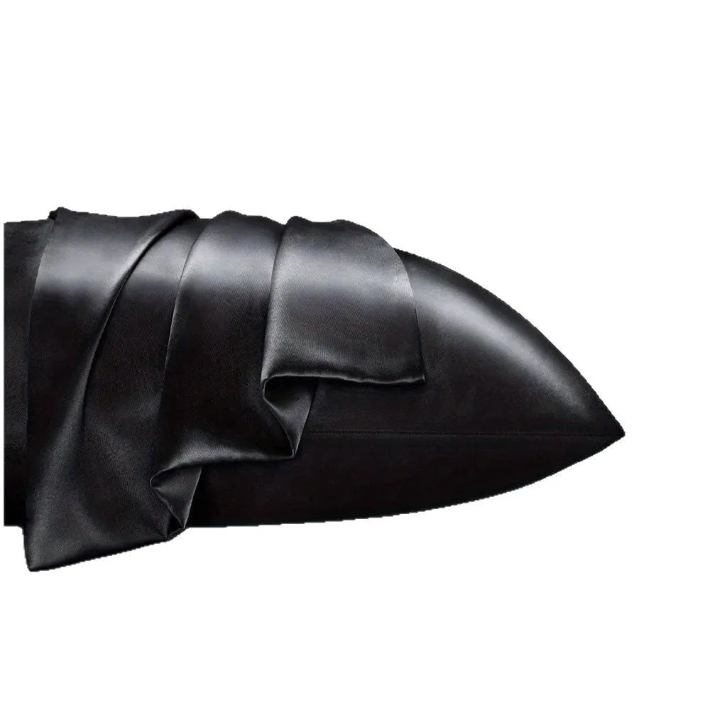 Pair of solid colour satin pillowcases in polyester fabric on a bed.