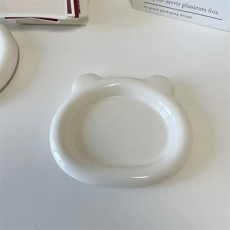 White porcelain plate with chubby toot or bear doodle pattern, shown in 15cm and 20cm round sizes.