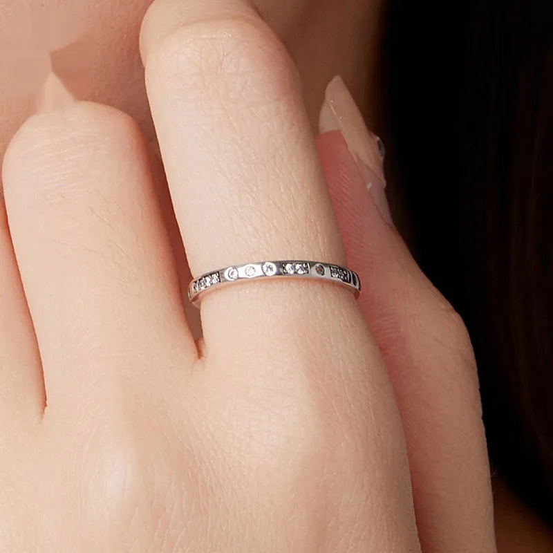Women's oxidised black silver 'I Love You' ring with moss password design on a hand.