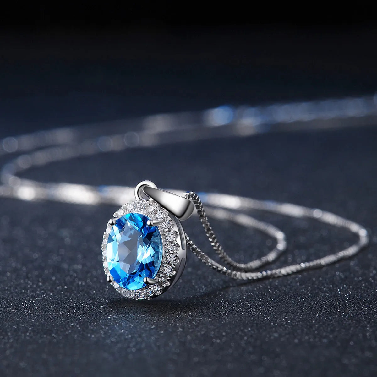 Women's 925 sterling silver jewellery set with blue topaz gemstones showing earrings, ring, pendant, and necklace with geometric pattern