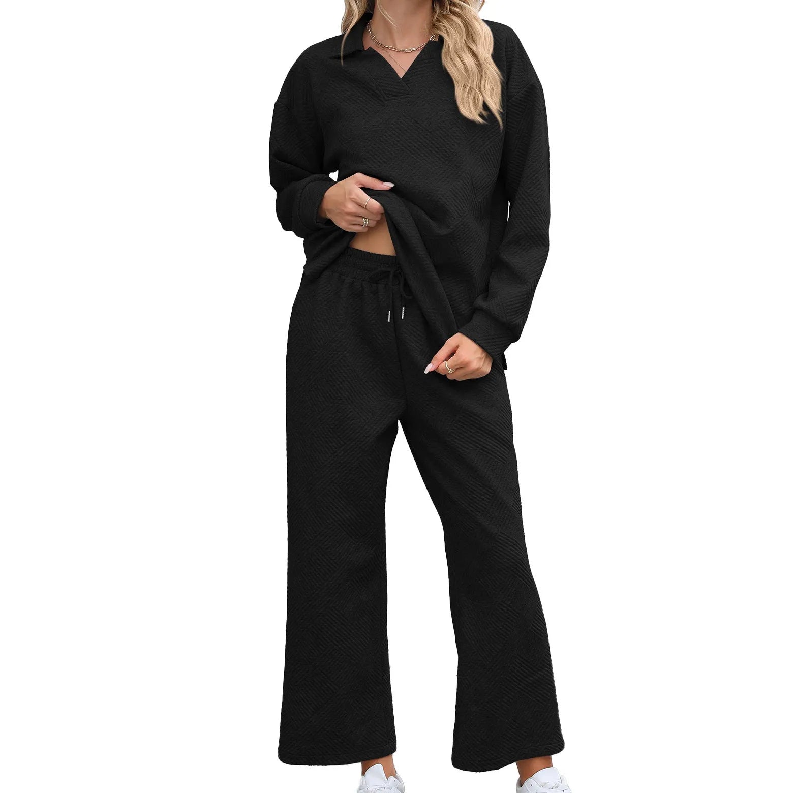Women's black geometric pattern knitted suit set with long sleeve top and elastic waist cropped trousers.