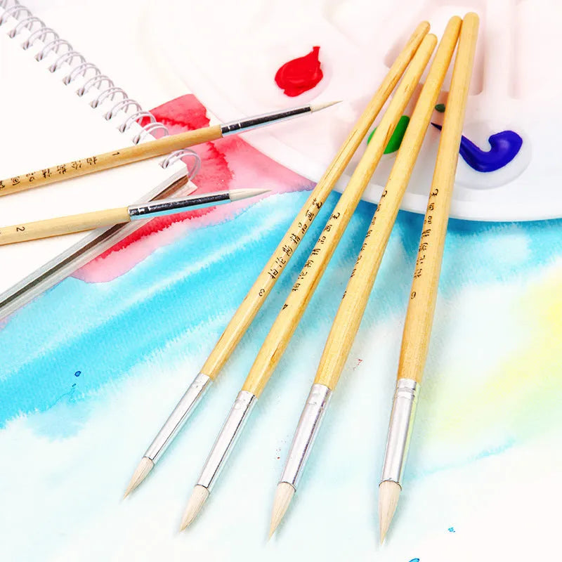 Six wooden pen brushes with pointed wool brush heads arranged as an artistic tool set