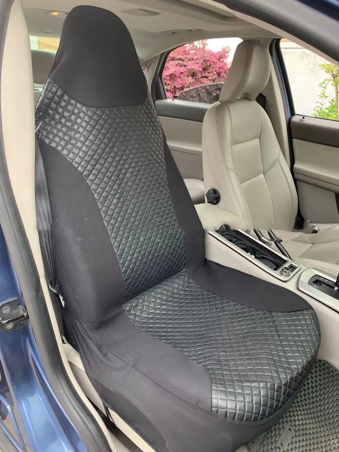 Black quilted automotive seat cover with PU and polyester construction shown on car seat