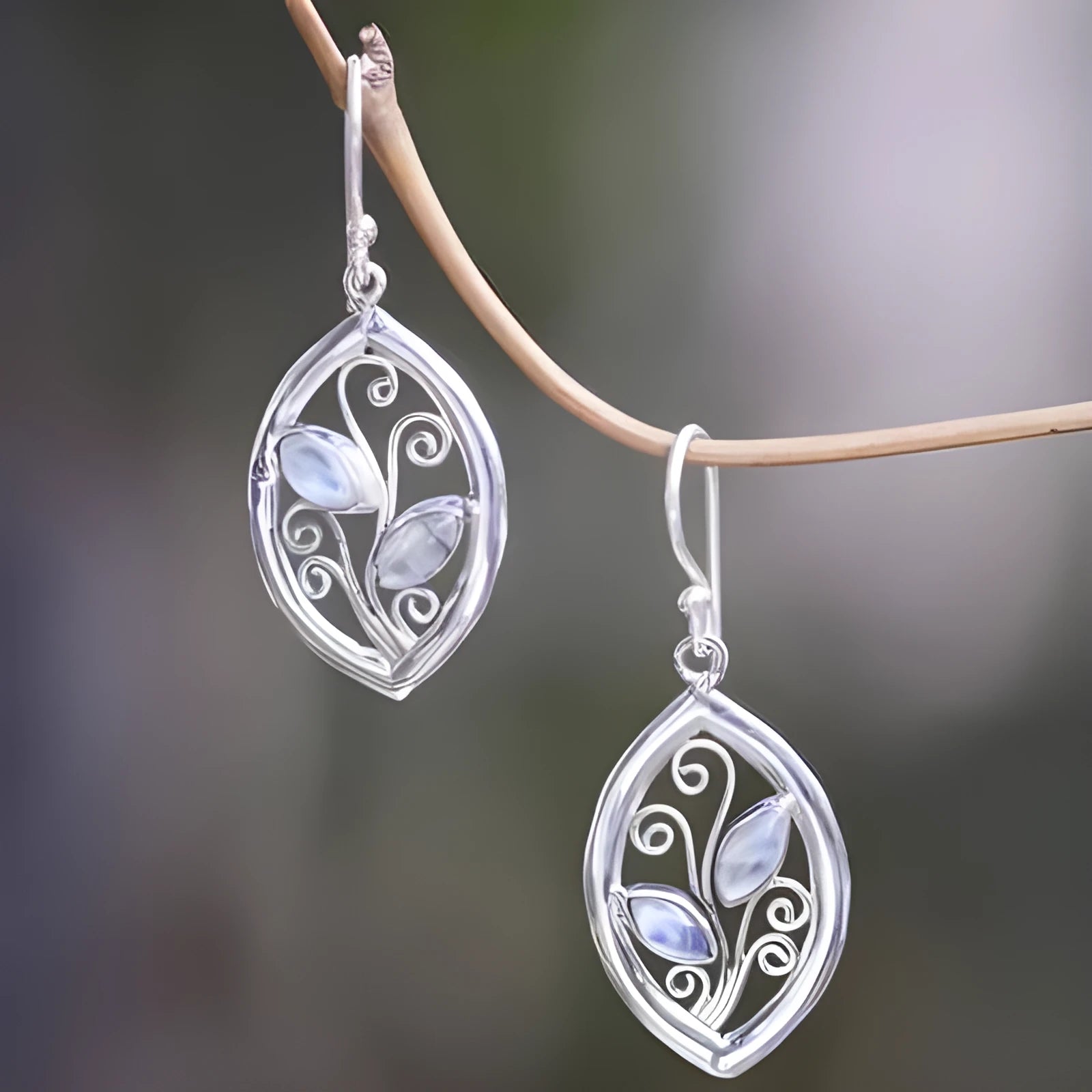 Women's silver colour leaves-shaped earrings with embedded moonstone stones and botanical design
