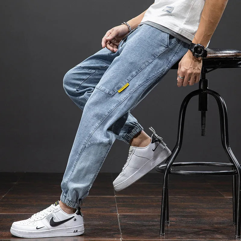 Men's loose-fit light blue cargo jeans with pockets and straight leg on a neutral background.