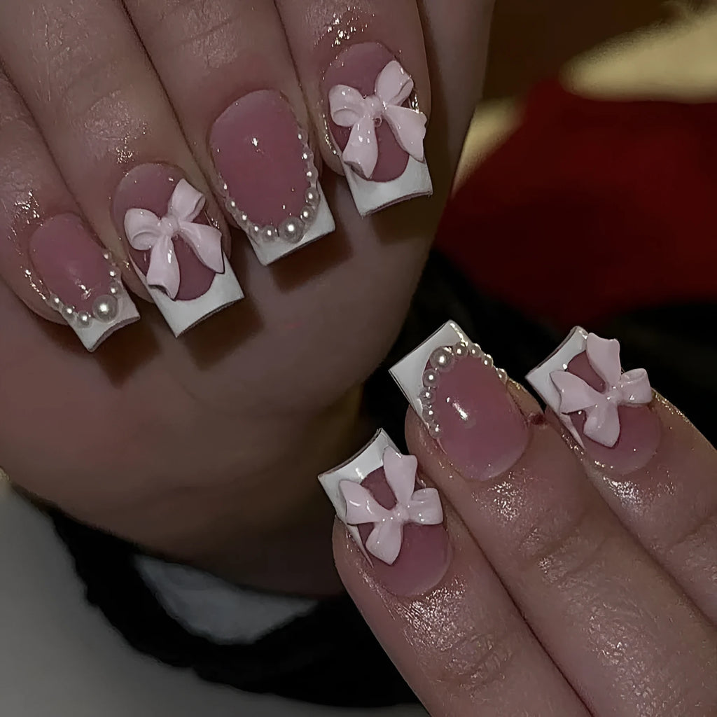 Set of short white French style press-on nail stickers with cute bow and tulip designs.
