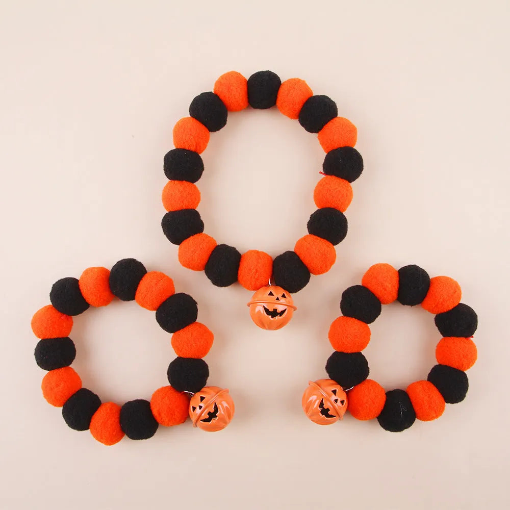 Orange Halloween cat collar with black pumpkin print and a silver bell, shown with an adjustable buckle.