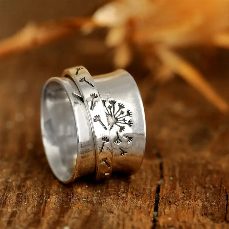 Silver rotatable flower ring on a finger showing the floral design.
