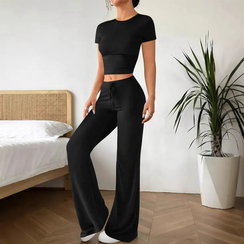 Black women's co-ord set with high waist trousers and regular sleeve T-shirt laid flat