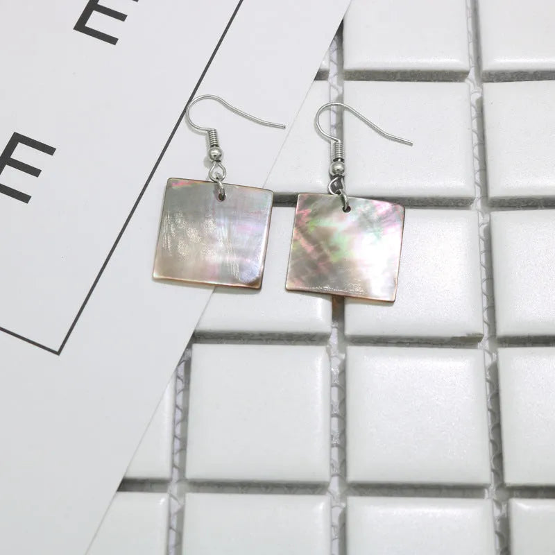 A pair of geometric-shaped women's earrings made from natural shell in a retro style.