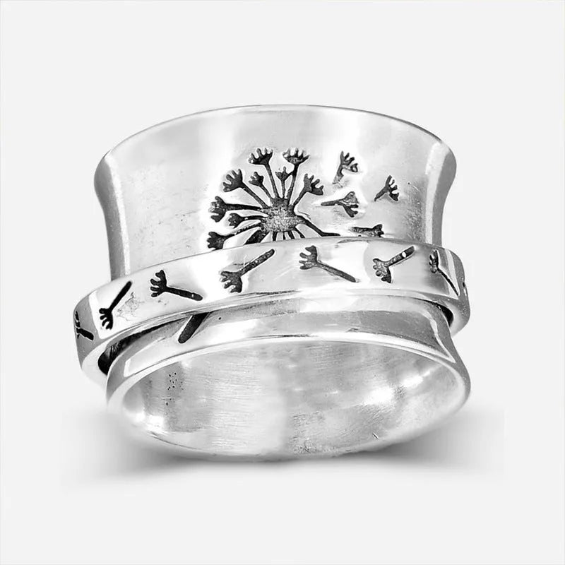 Silver rotatable flower ring on a finger showing the floral design.