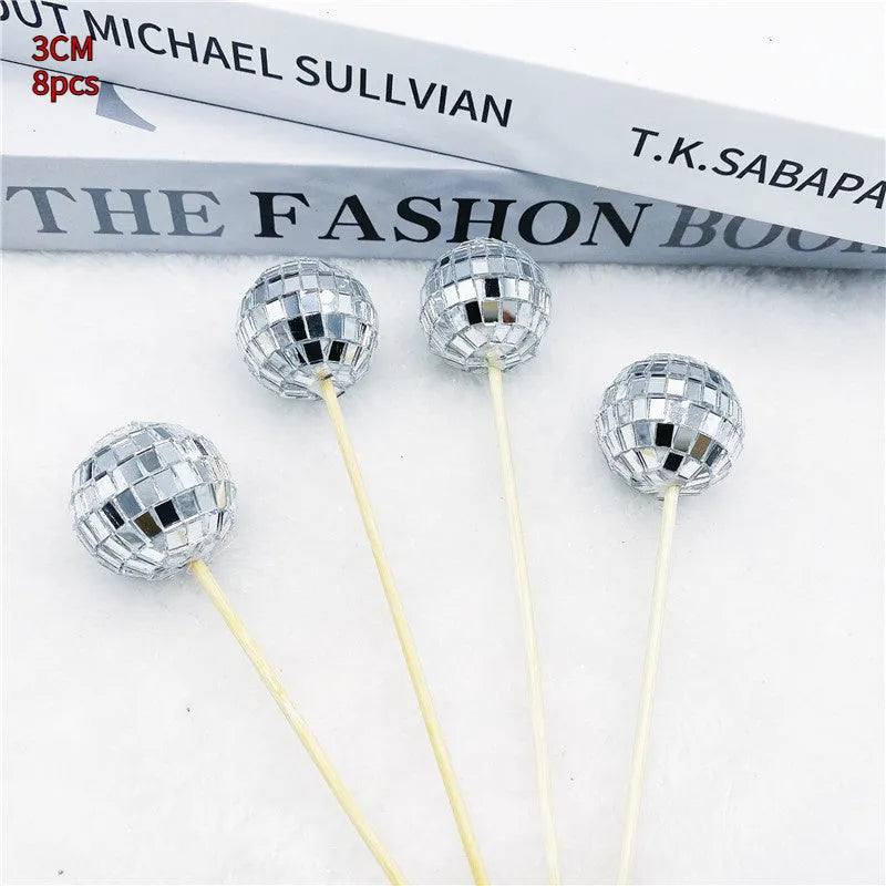 Glass disco ball cake decoration on a wooden stick, shown in different sizes for birthday cakes.
