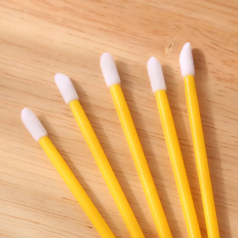 Disposable lip brush applicators with flocked heads in multiple handle colours on white background