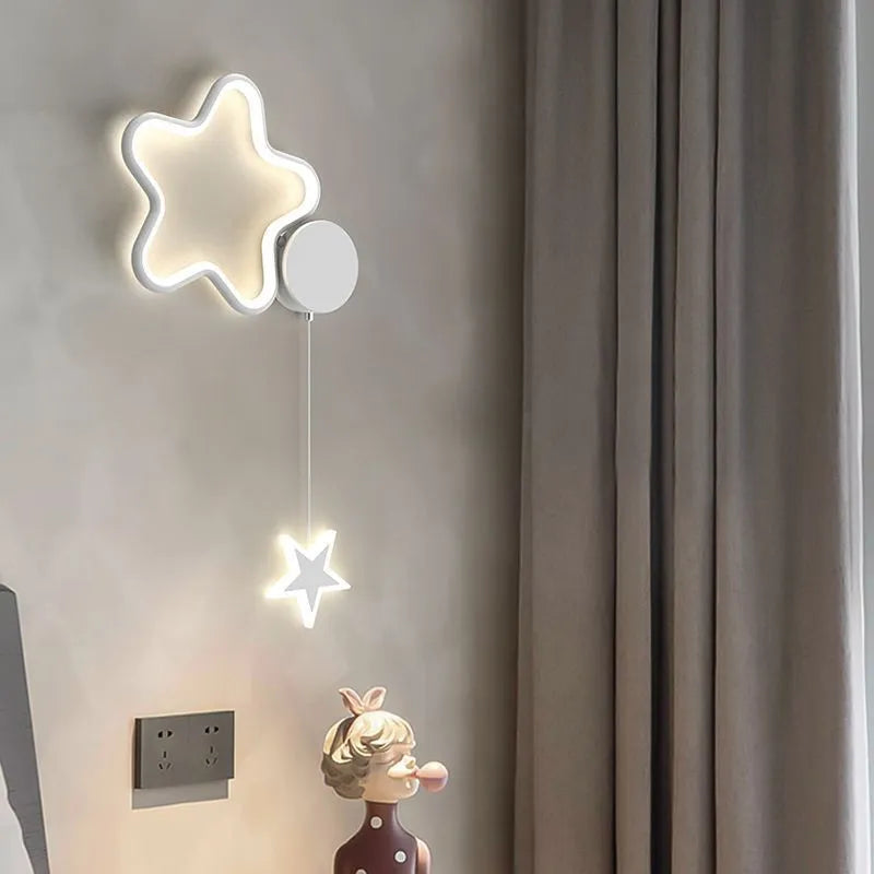 Children's bedside wall lamp with cloud and star design in black finish showing three-colour LED illumination