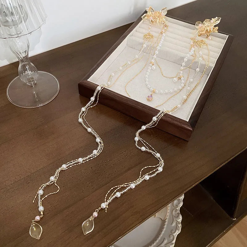 Gold-coloured acrylic hairpin with a pearl diamond flower and long tassel decoration.