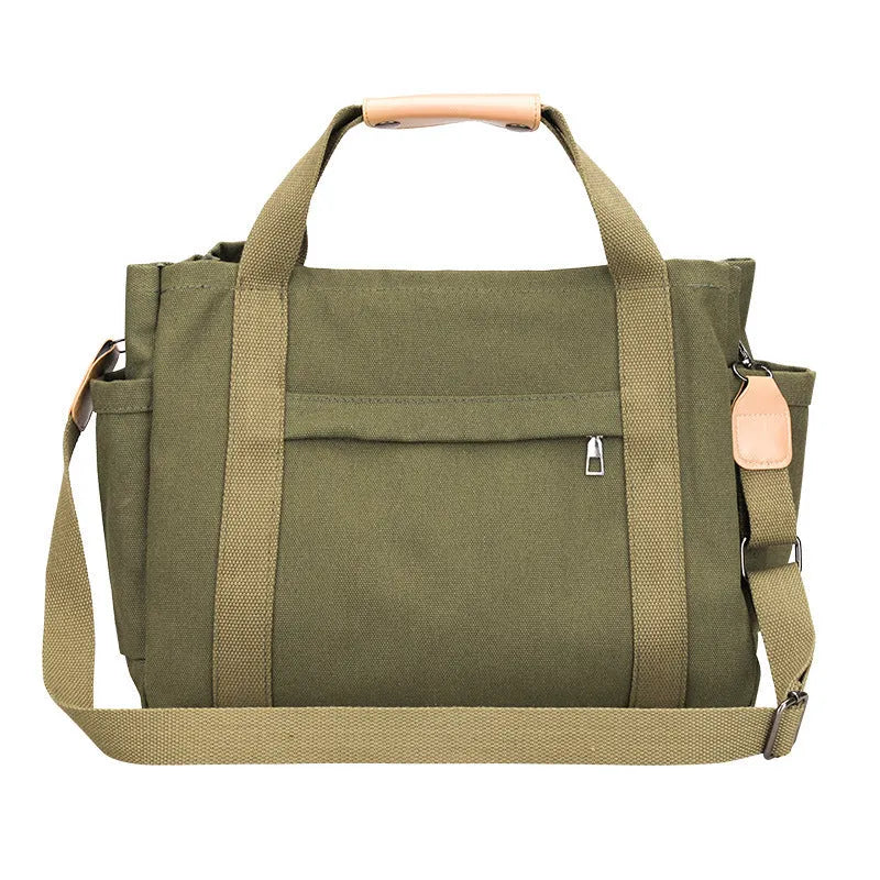 Large horizontal square canvas tote bag with cross-body strap, shown in army green colour with visible sewing lines.