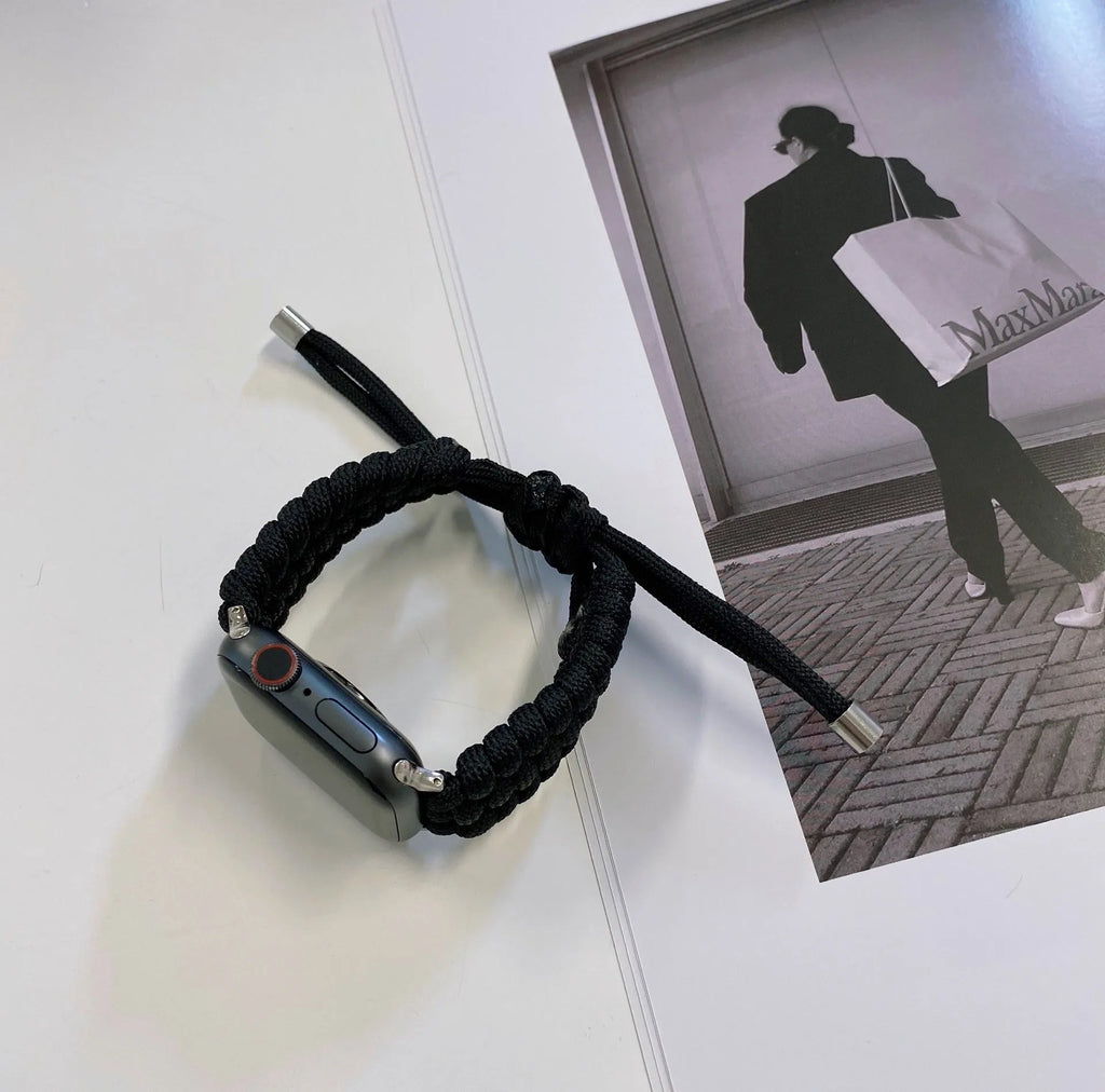 Braided paracord smart watch strap in black, shown detached from a watch, with standard connector lugs.
