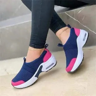 Women's flat mesh sneakers in light grey with white rubber soles and colour stitching.