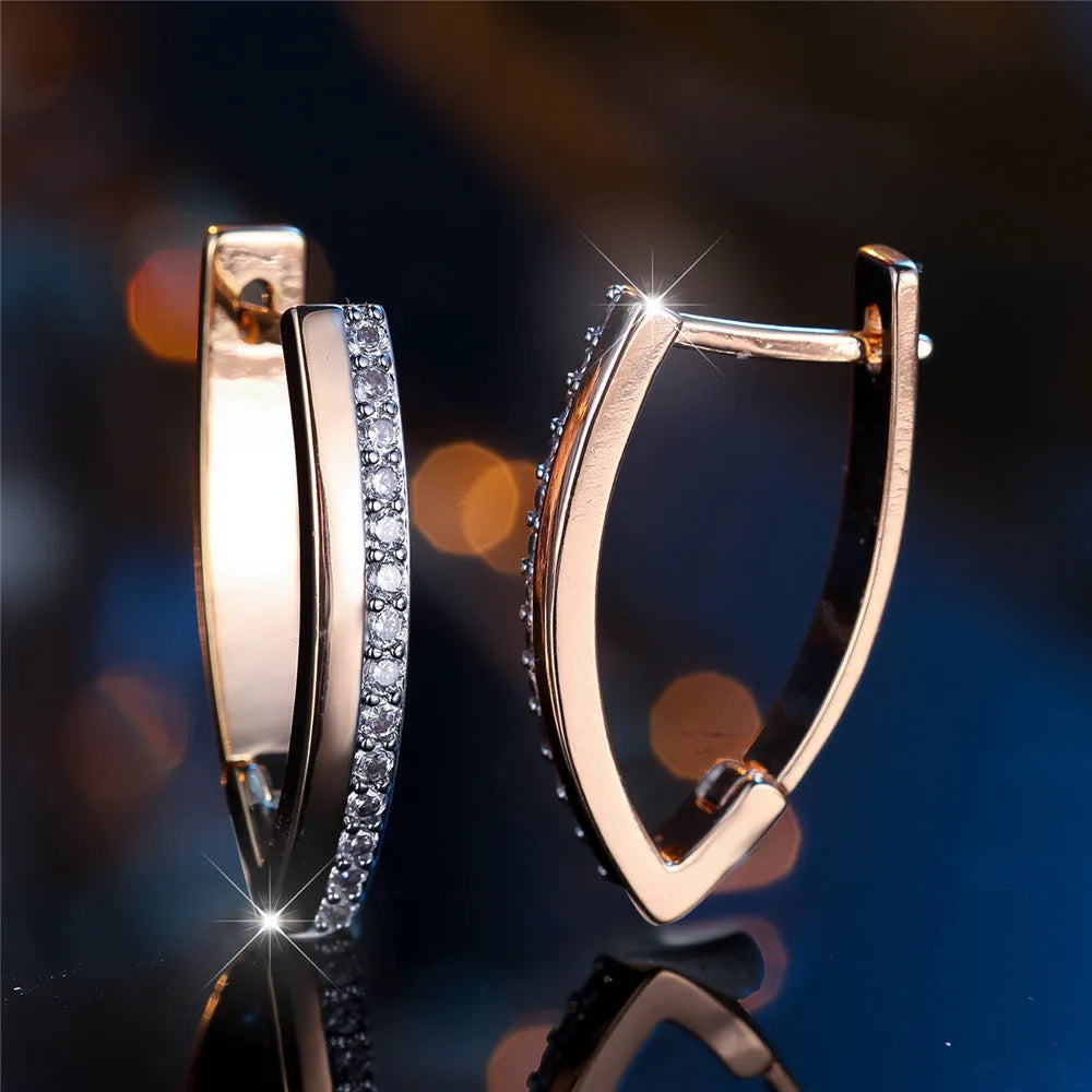 Women's geometric drop earrings with champagne gold electroplating and white diamond accents, showing V-shaped design and clip-on back.