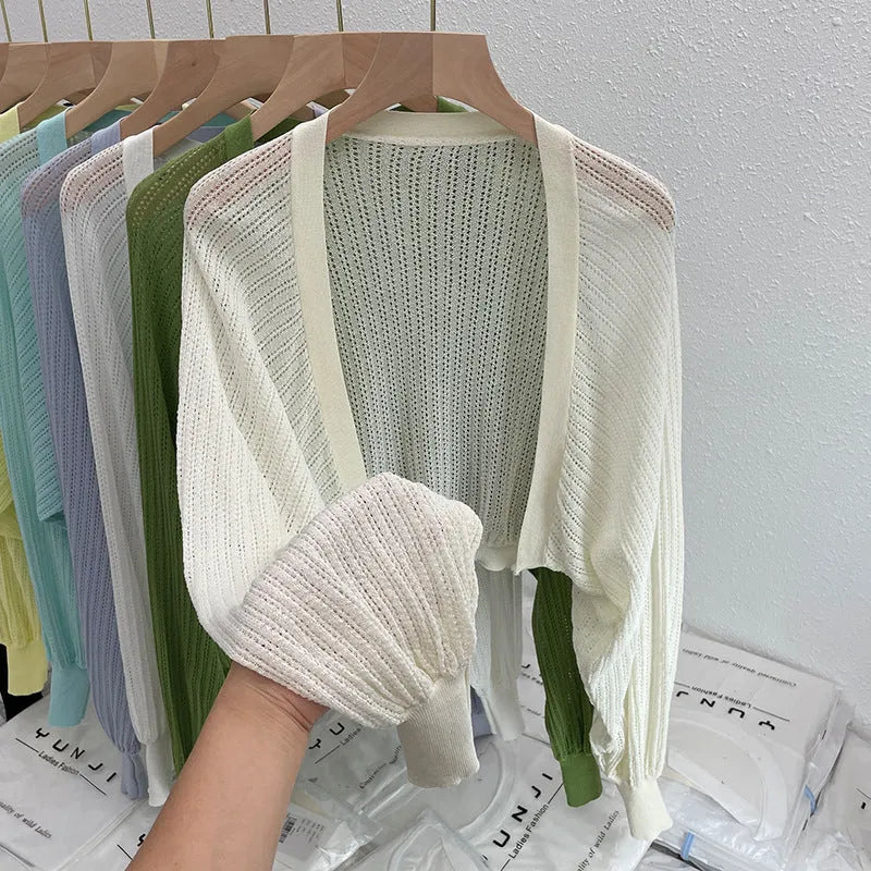 Thin loose linen blouse with hollow out lantern sleeves in apricot colour on a hanger.