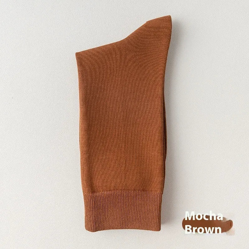Men's solid colour pure cotton mid-calf business socks in beige, black, grey and blue shown folded.
