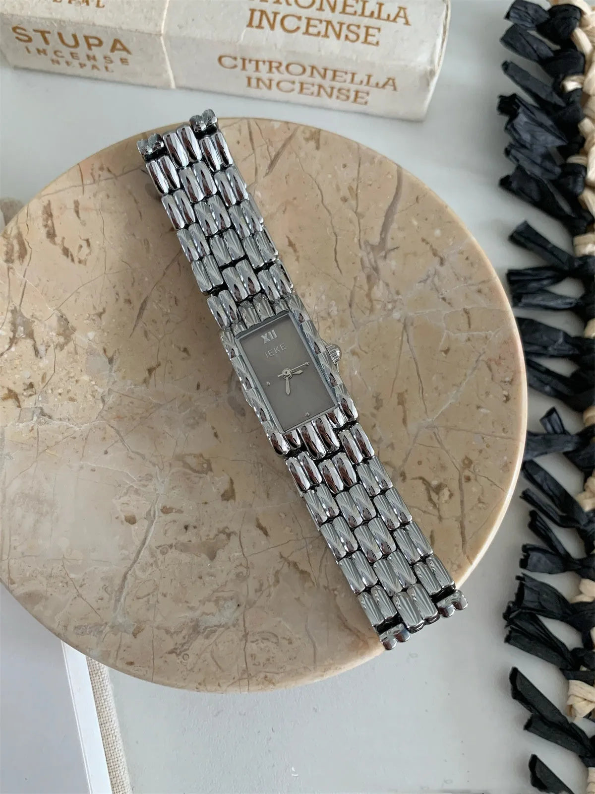 Women's silver and gold bracelet-style vintage watch with 15mm dial on wrist