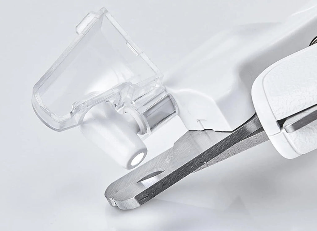 White pet nail clippers with LED light, open transparent splash guard, and separate nail file on a table