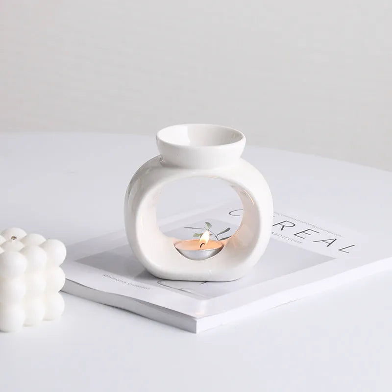 White ceramic Nordic-style aromatherapy stove ornament on a wooden surface.