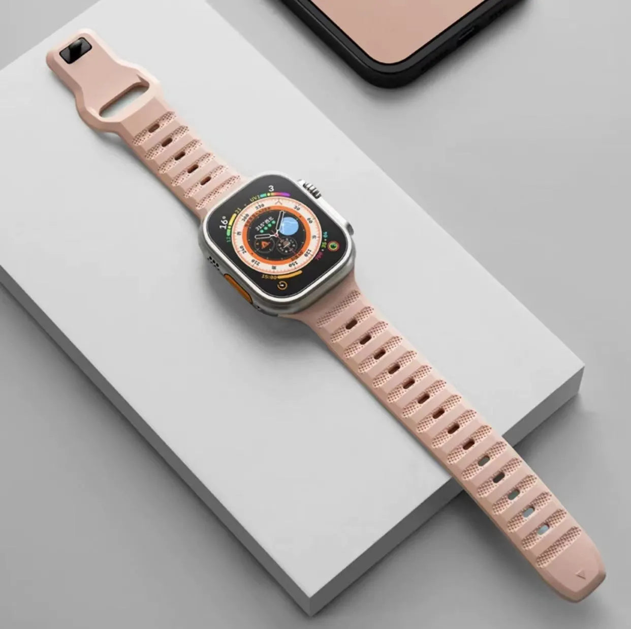 Fluoro rubber Apple Watch band with T-buckle in multiple colours on a grey background