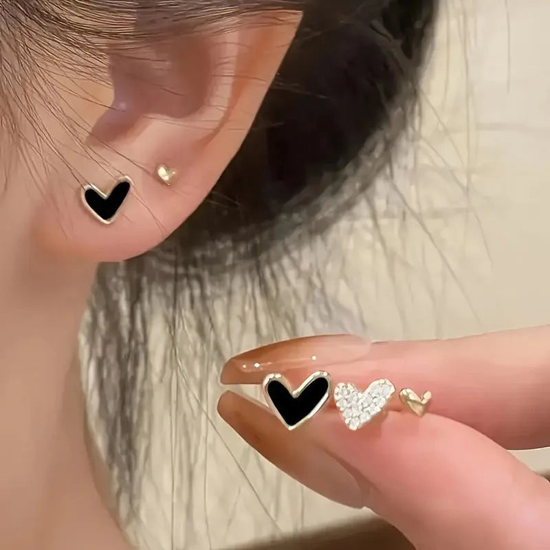 Three pairs of heart-shaped alloy earrings with love motifs in four colour options