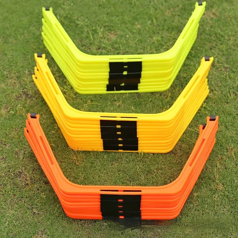 Set of six foldable yellow green and orange hexagon football agility training rings on grass.