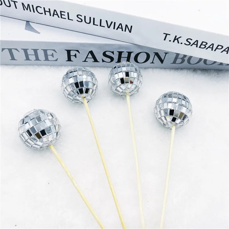 Glass disco ball cake decoration on a wooden stick, shown in different sizes for birthday cakes.