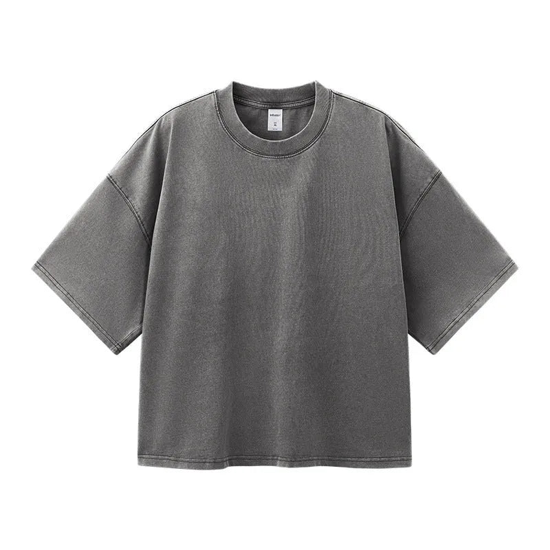Man wearing a vintage washed khaki cotton t-shirt with loose fit and drop-shoulder sleeves.