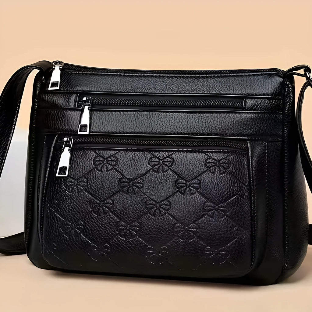 Women's black PU leather crossbody shoulder bag with embossed pattern and phone pocket