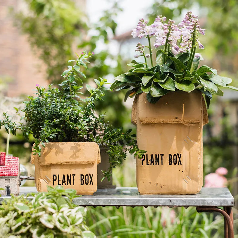 Cement flowerpot with brown paper box design featuring drainage holes