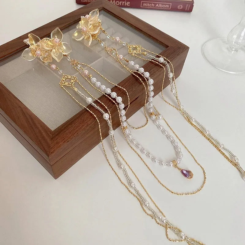 Gold-coloured acrylic hairpin with a pearl diamond flower and long tassel decoration.