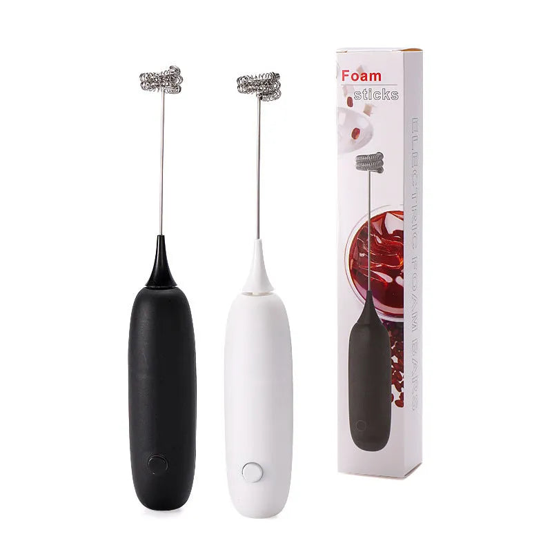Black and white electric hand-held milk frother for coffee drinks