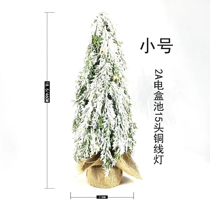 Small 24-inch white artificial Christmas tree with LED lights and snow-covered branches on a desktop.