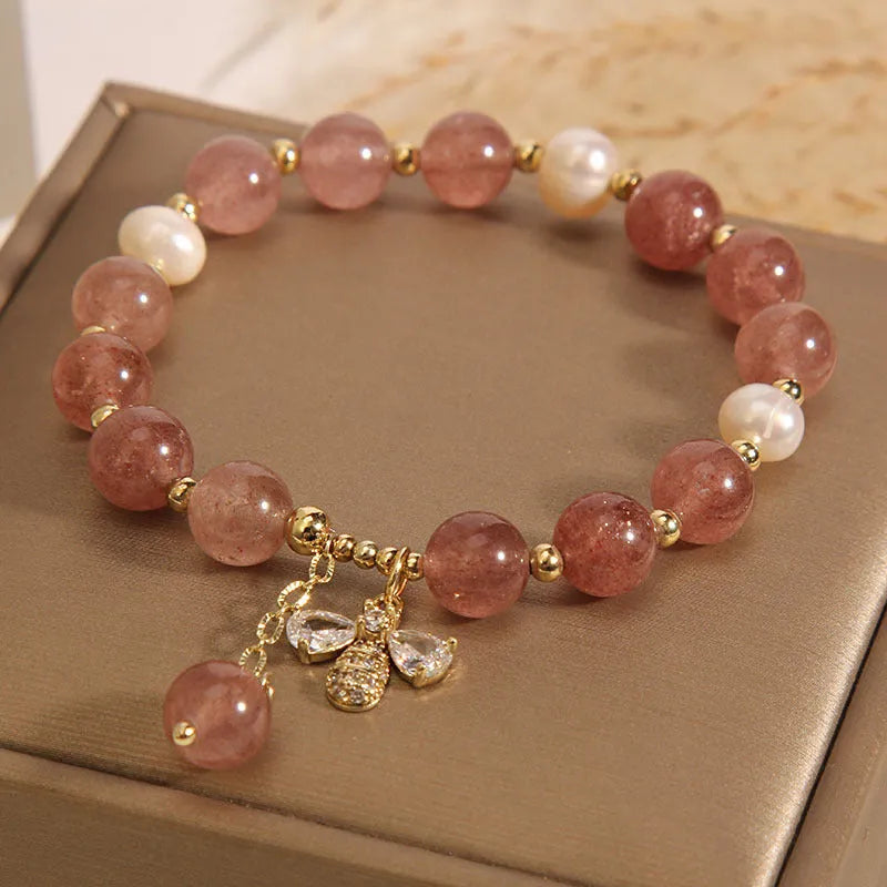 Strawberry quartz and freshwater pearl bracelet with zircon accents on woman's wrist