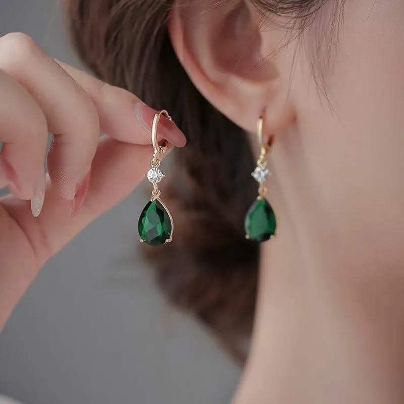 A pair of green geometric teardrop-shaped alloy earrings on a white background.