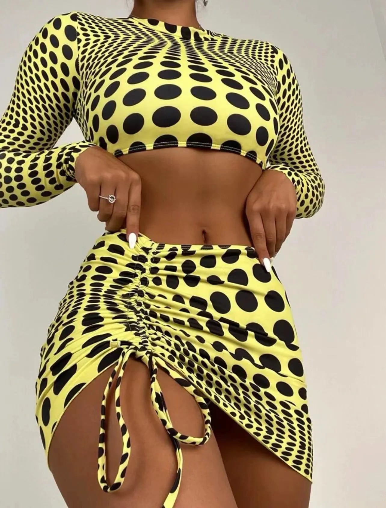 Green and yellow polka dot women's swimsuit three-piece set with top, skirt, and bra.