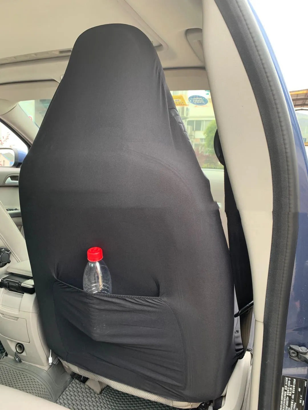 Black quilted automotive seat cover with PU and polyester construction shown on car seat