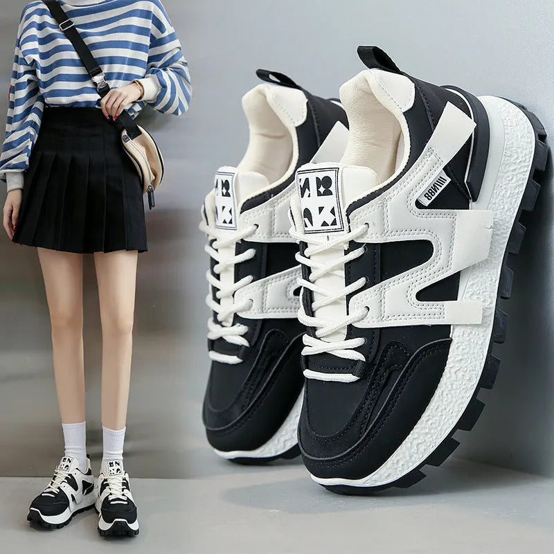 A pair of low-top black or white sneakers with a round toe, lace-up front, and flat rubber sole.