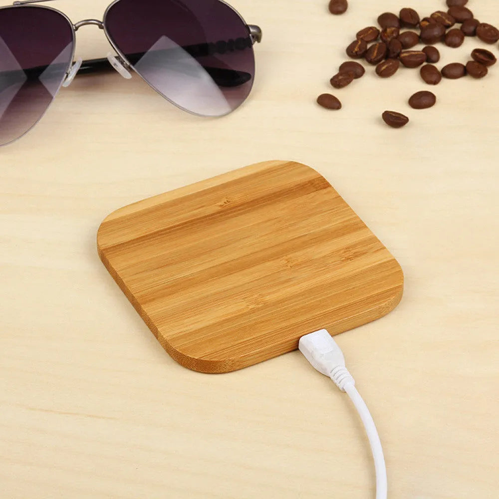 Square wooden bamboo 5W Qi wireless charging pad on a desk.