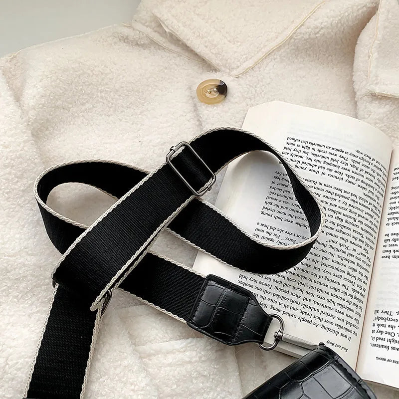 Vintage PU crossbody bag in black, shown with adjustable strap and open to reveal polyester lining.
