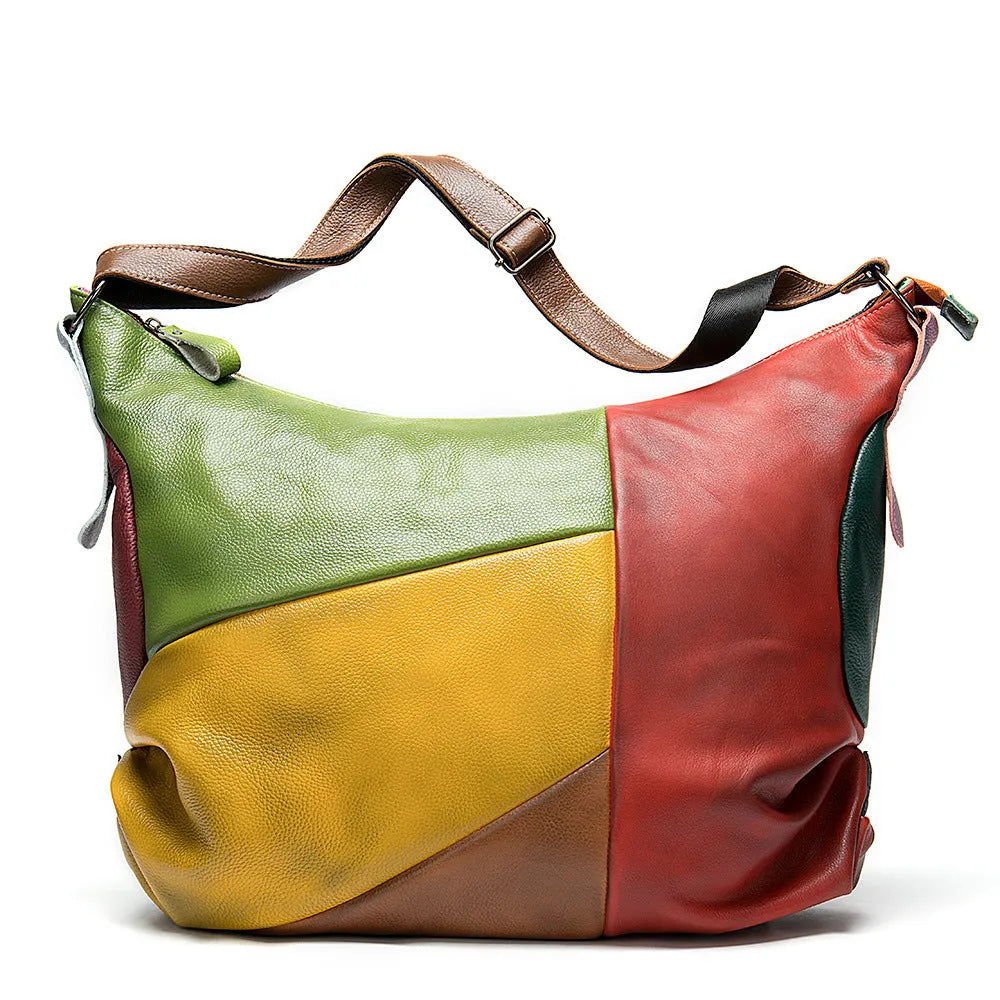Brown cowhide leather crossbody travel bag with stitching detail, shown holding a laptop and A4 magazine.
